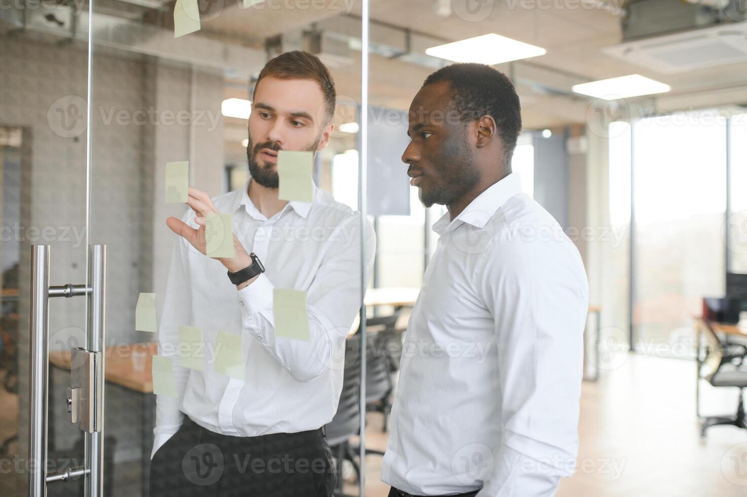 Young businessman manager writing strategy ideas on sticky notes. Business project planning. photo
