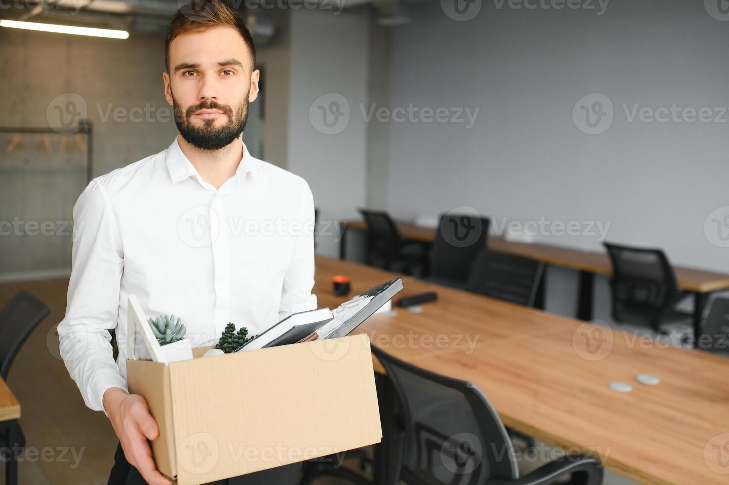 Man by dismissal. Guy lost job. Fired manager in company. Dismissal box in hands of employee. photo