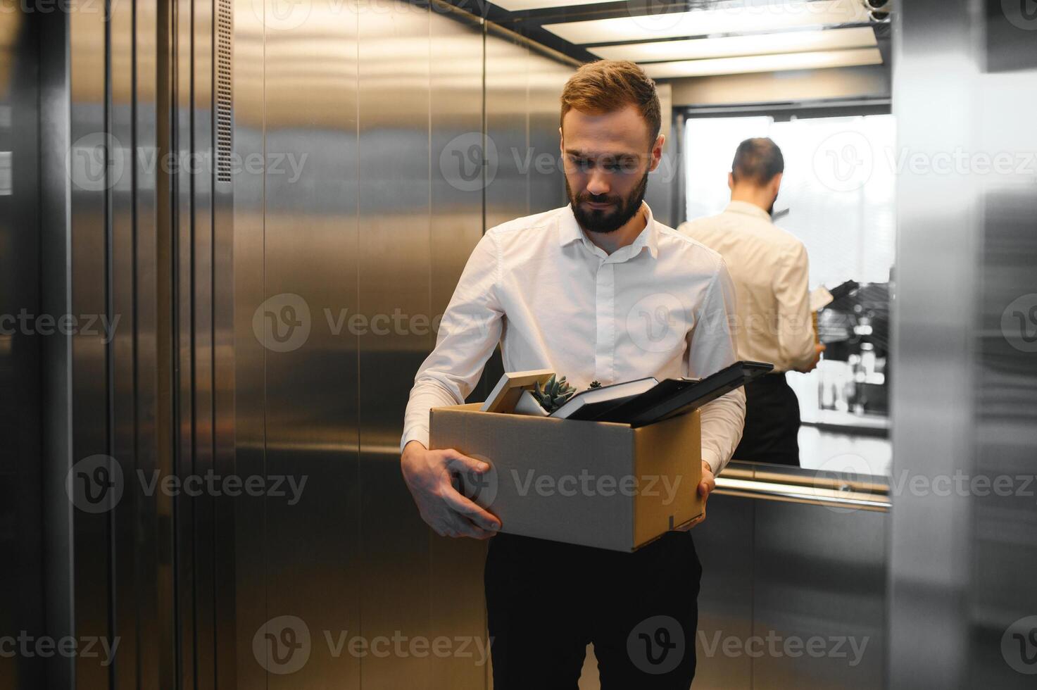 Man by dismissal. Guy lost job. Fired manager in company. Dismissal box in hands of employee. photo