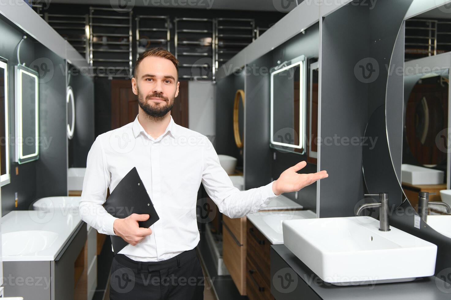 Happy salesman plumber man with paper tablet on plumbing shop photo