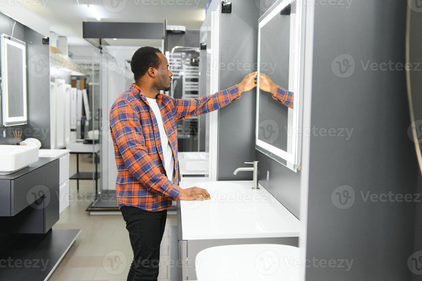 africano americano a el edificio mercado mirando para lavabo dentro su baño foto