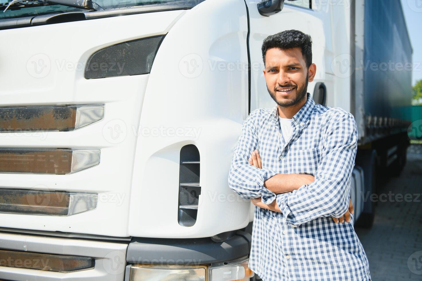 Young indian man standing by his truck. The concept of freight transportation. photo