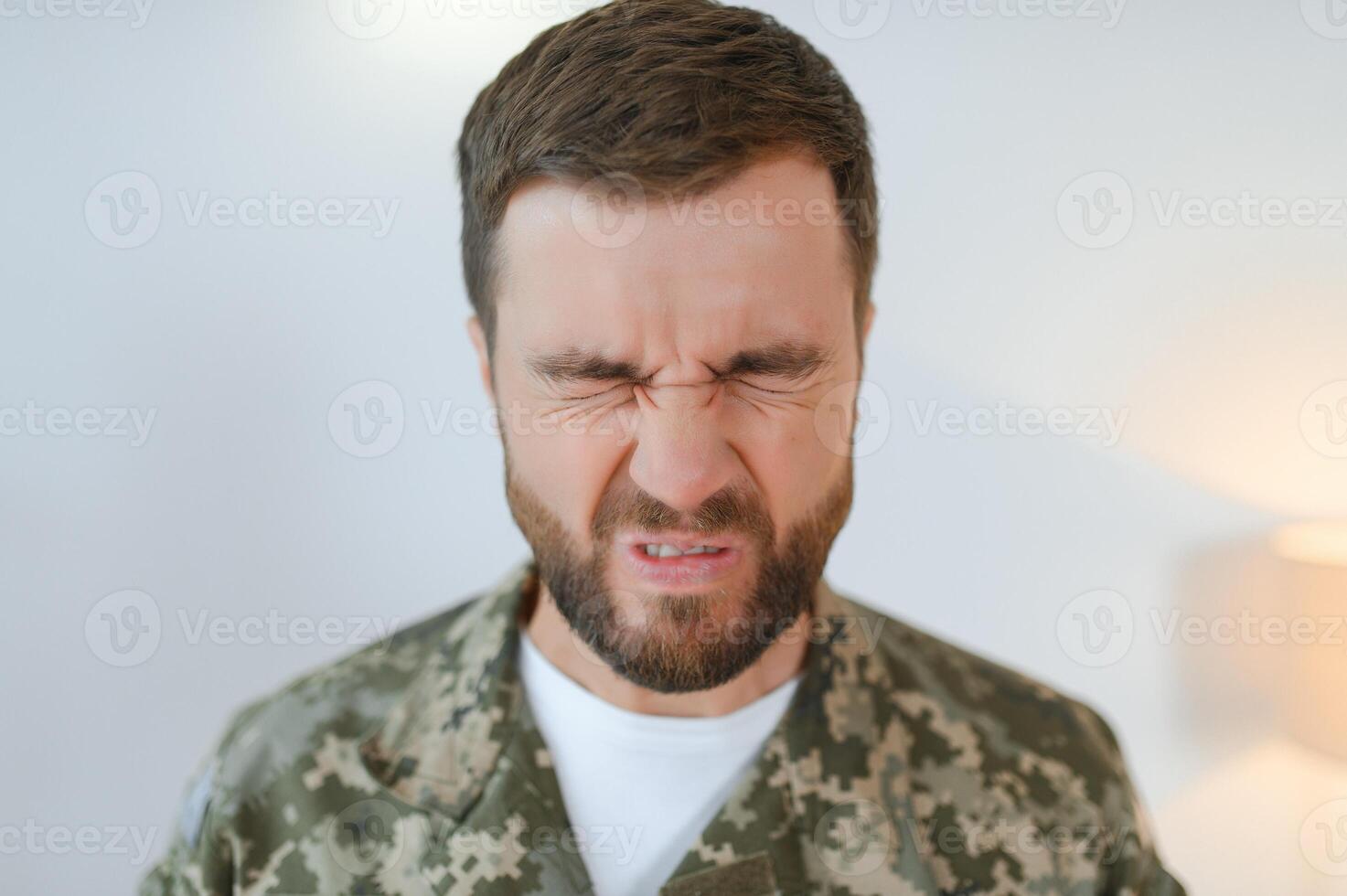 Depressed man recalling war days. Portrait of veteran soldier who has PTSD photo