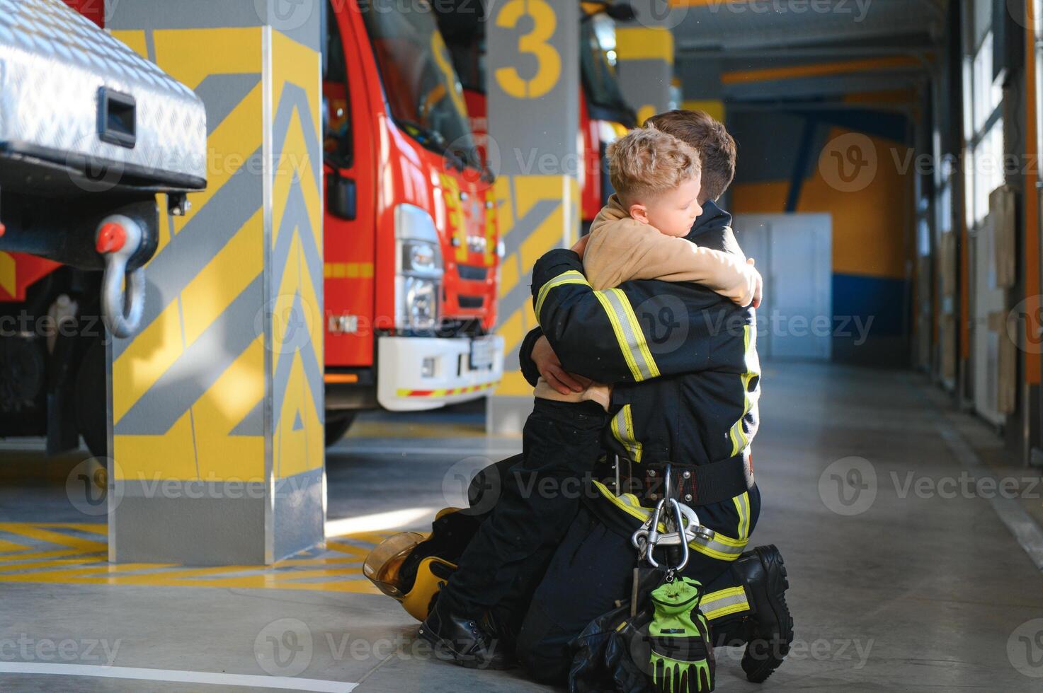 A firefighter take a little child boy to save him. Fire engine car on background photo