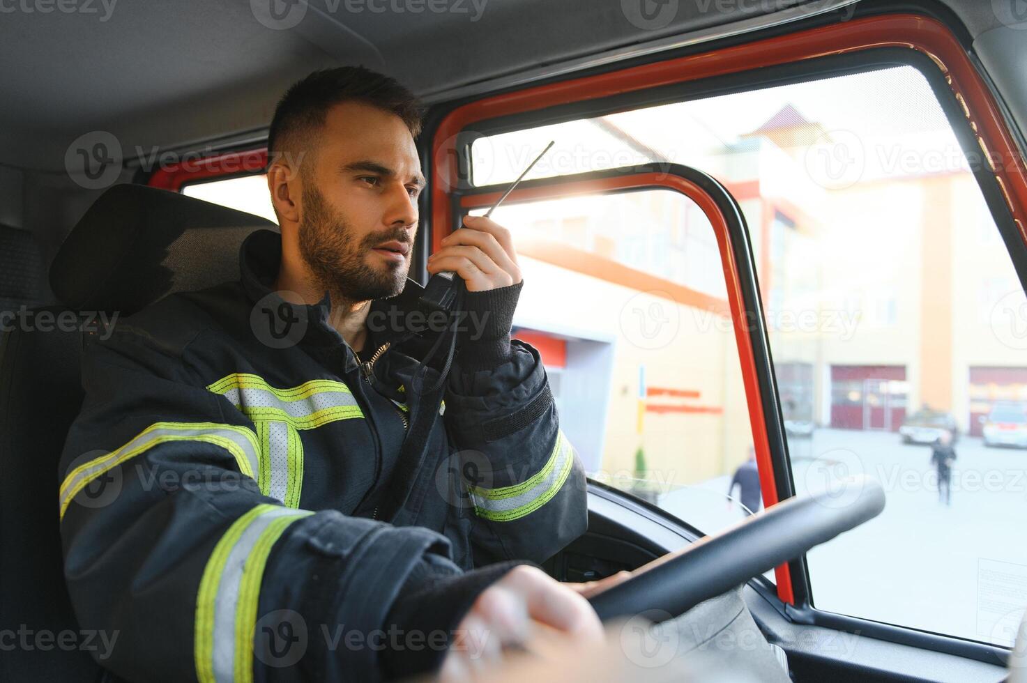 Firefighter using radio set while driving fire truck 38350980 stock