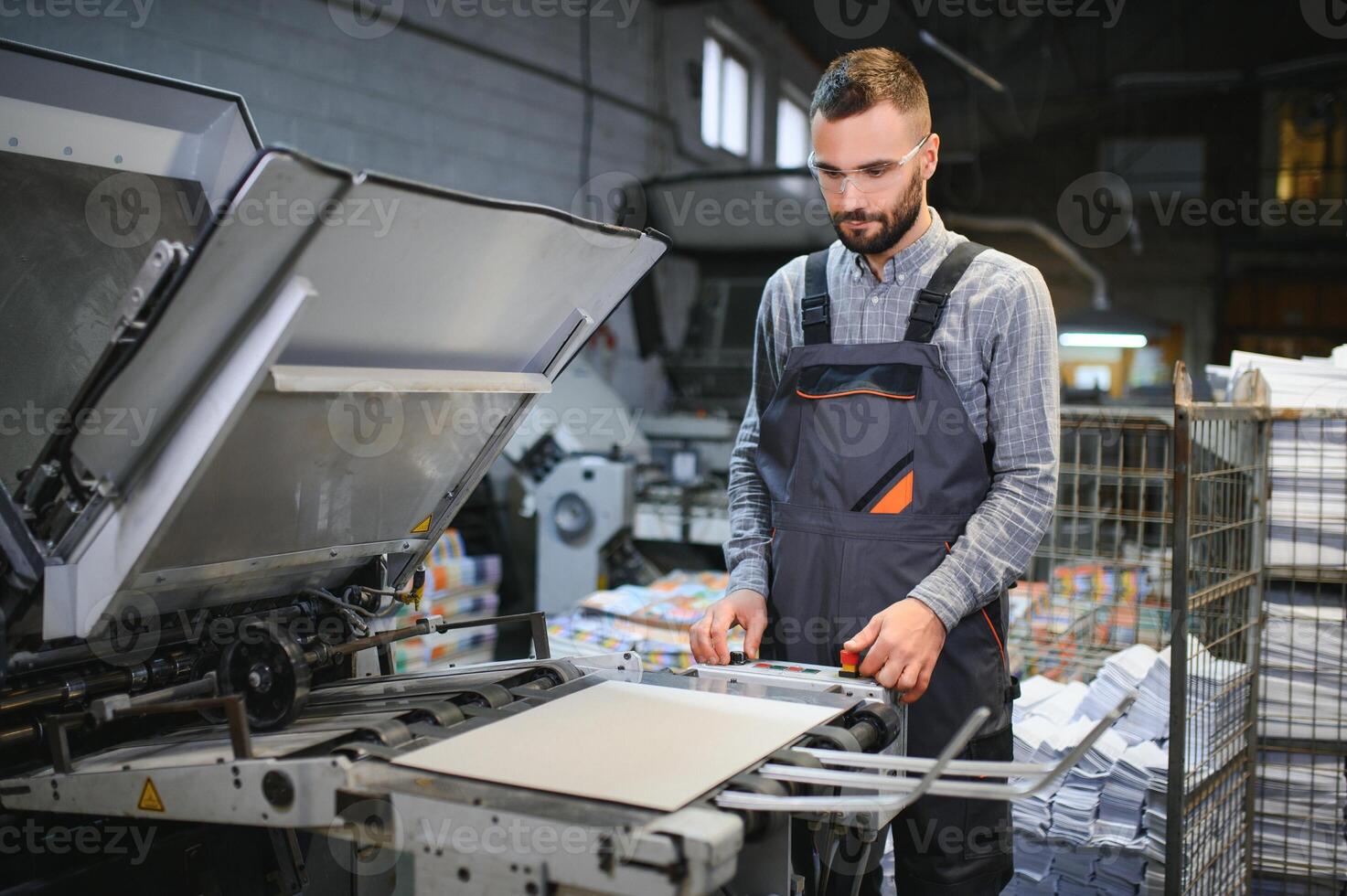 Graphic engineer or worker checking imprint quality in modern print shop photo