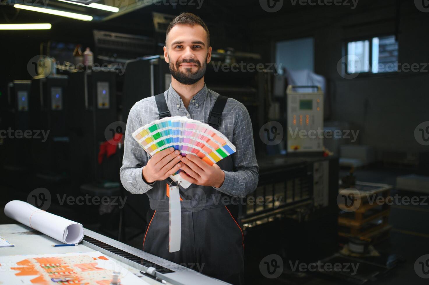 Typographer standing with color swatches at the printing manufacturing photo