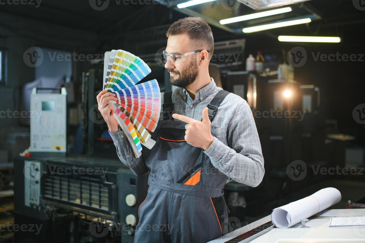 Typographer standing with color swatches at the printing manufacturing photo