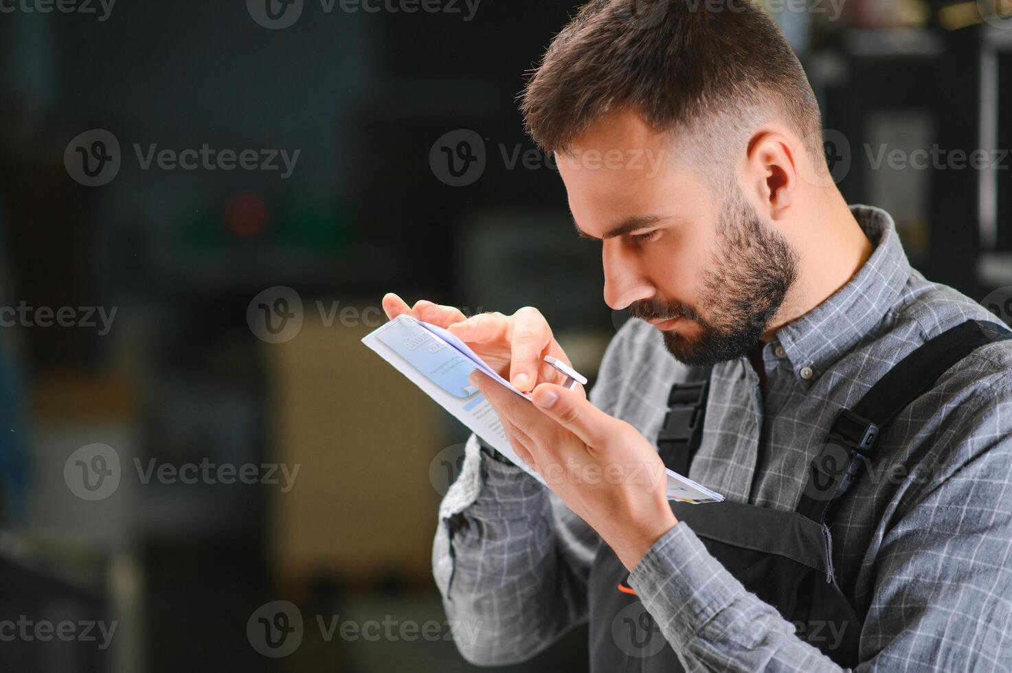 Print house worker controlling printing process quality and checking colors with magnifying glass photo