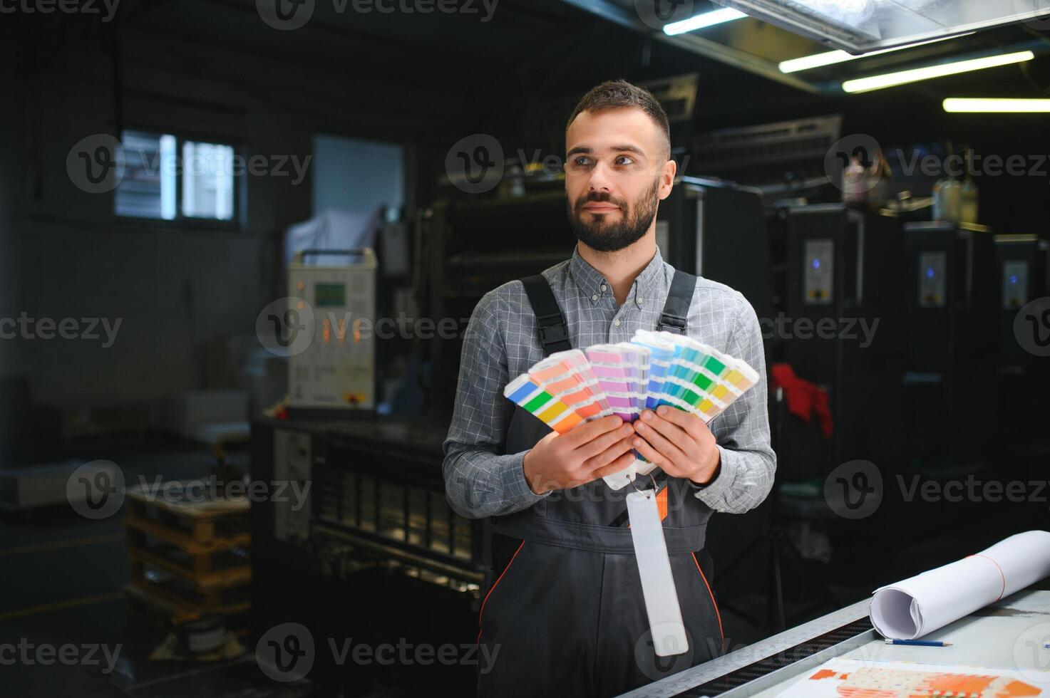 Typographer standing with color swatches at the printing manufacturing photo