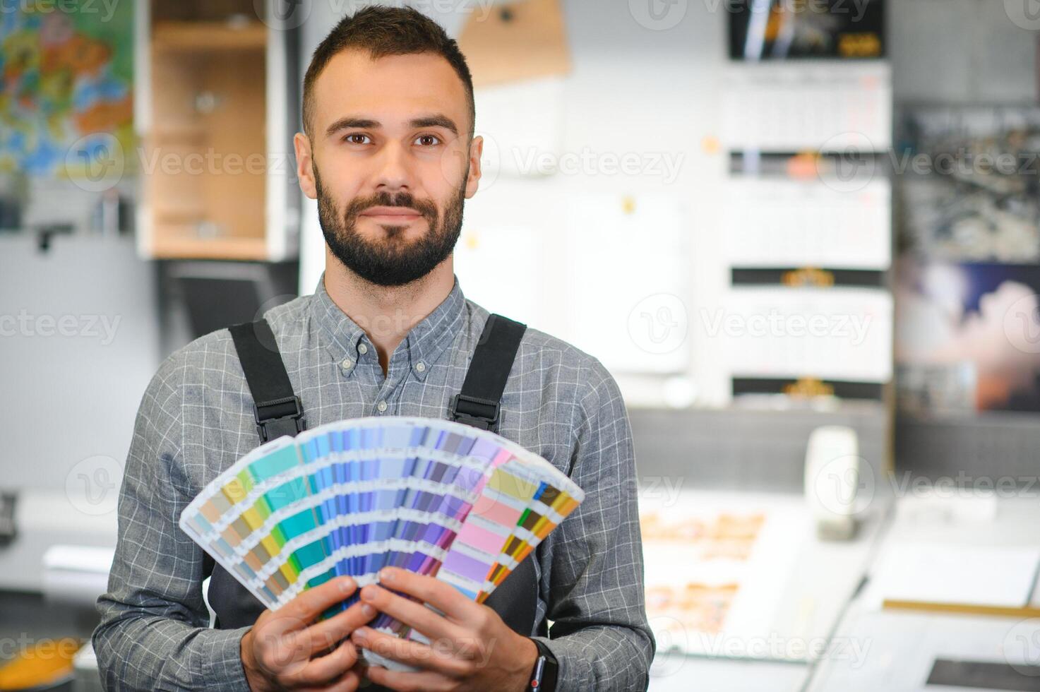 Typographer standing with color swatches at the printing manufacturing photo