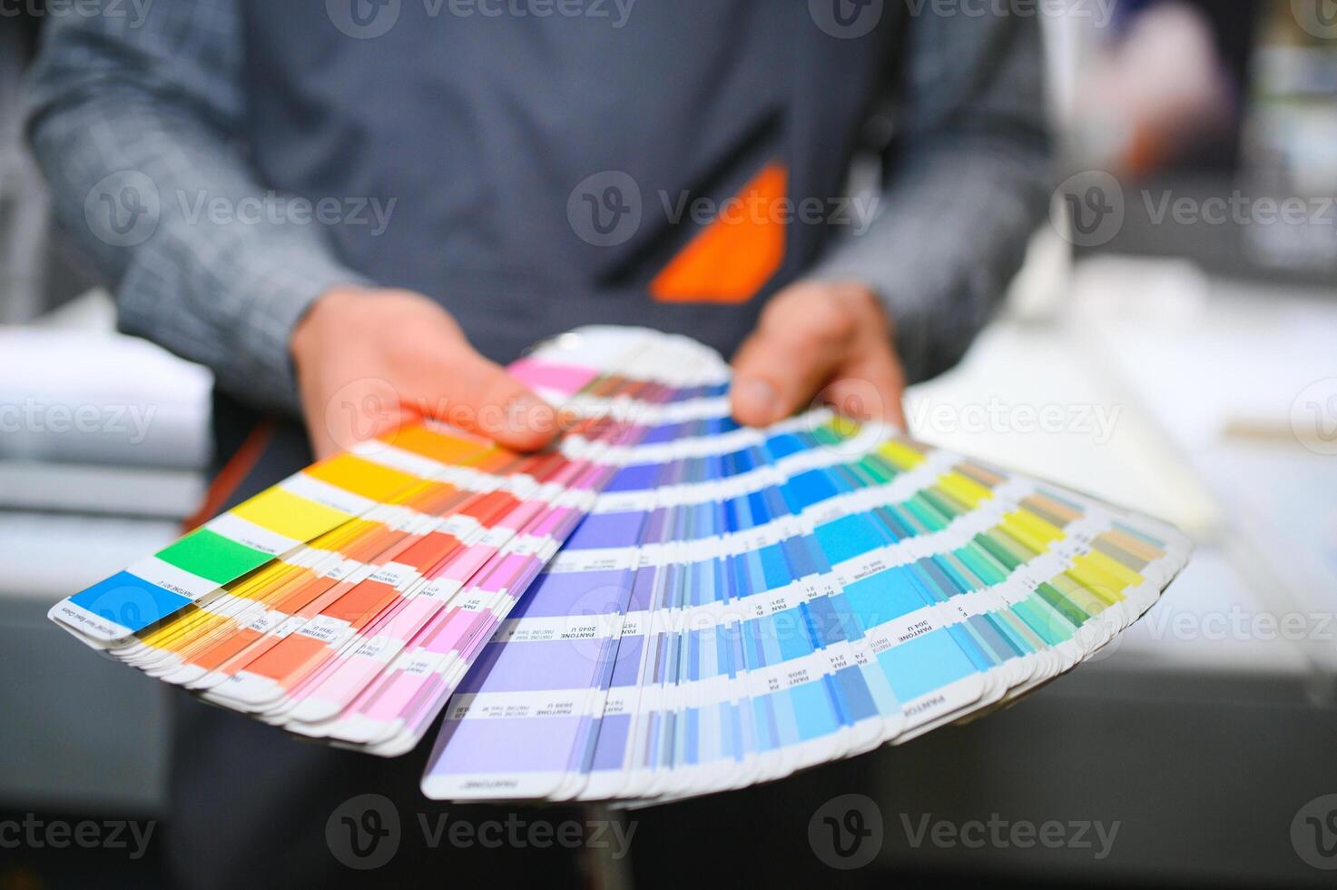 Typographer standing with color swatches at the printing manufacturing photo