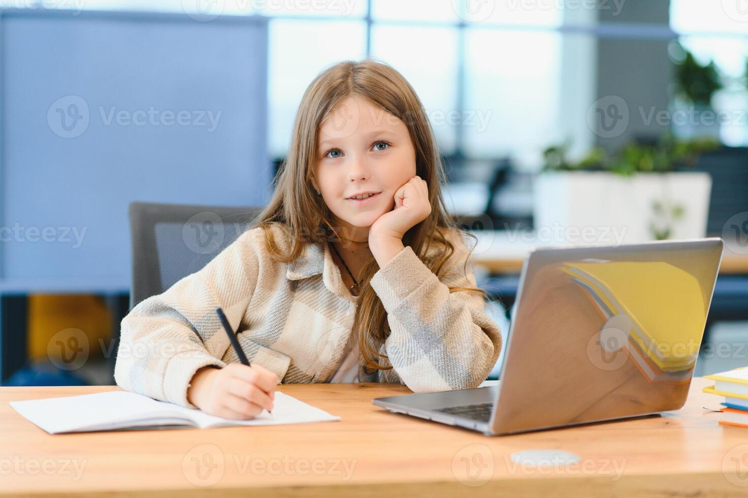 First day at school. Cute and happy little girl children using laptop computer, studying through online e-learning system photo