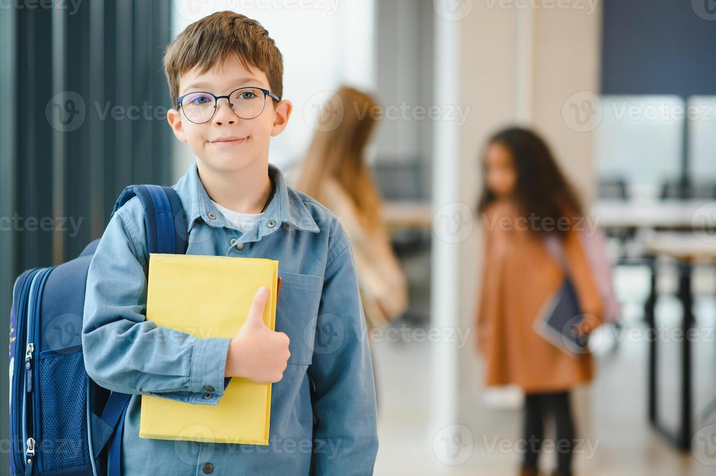 Schoolboy with schoolbag and books in the school. Education concept. Back to school. Schoolkid going to class. Stylish boy with backpack. Boy ready to study photo