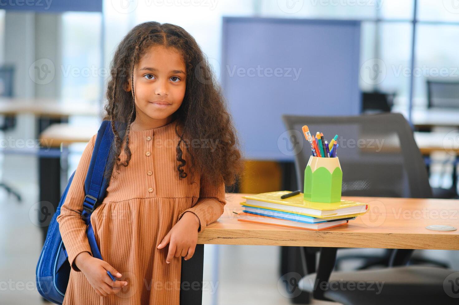 African-American girl in school looking at camera while standing in classroom, copy space photo