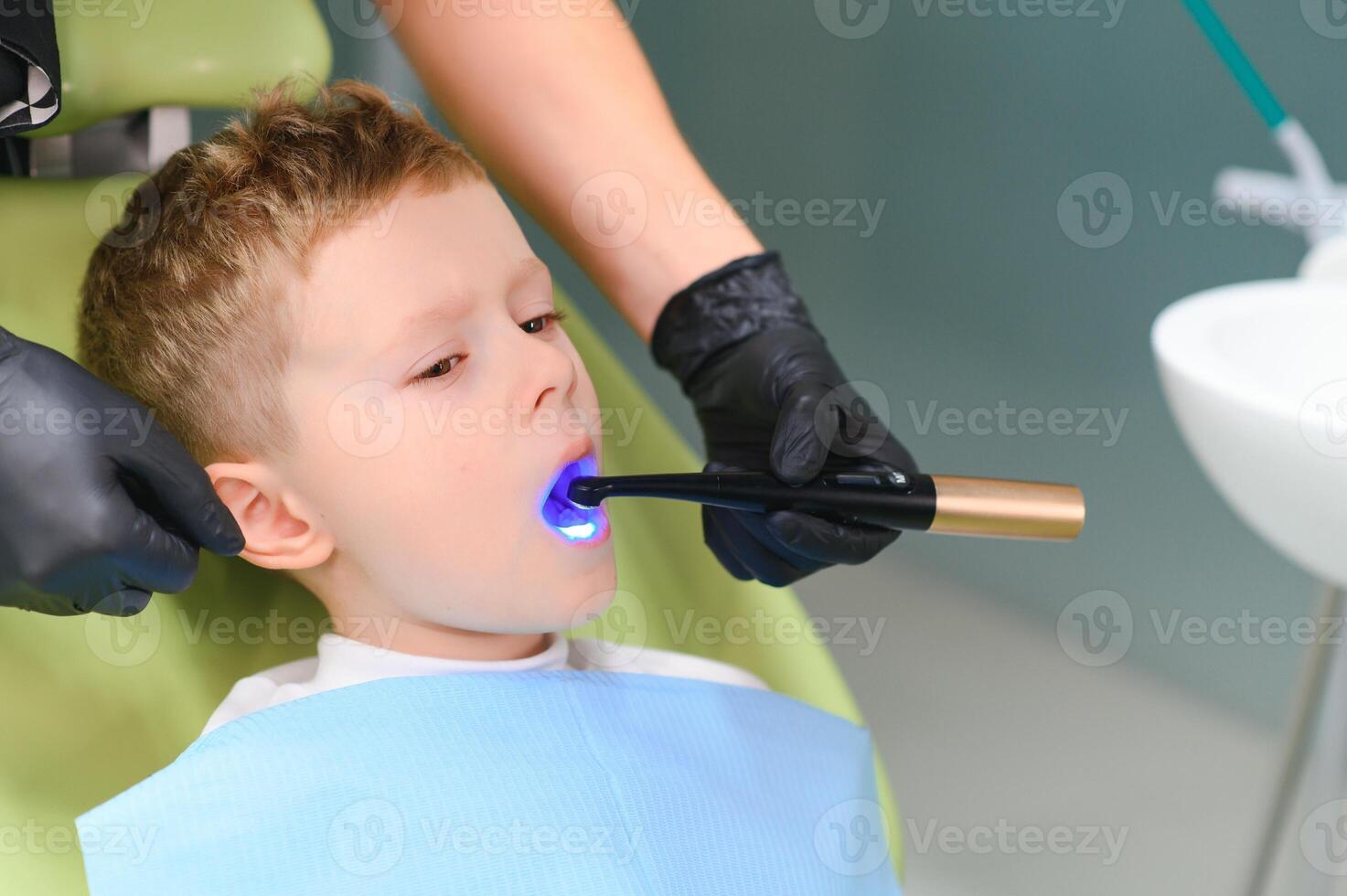 Scared red-haired boy crying at reception at dentist in dental chair. Pediatric dentistry photo