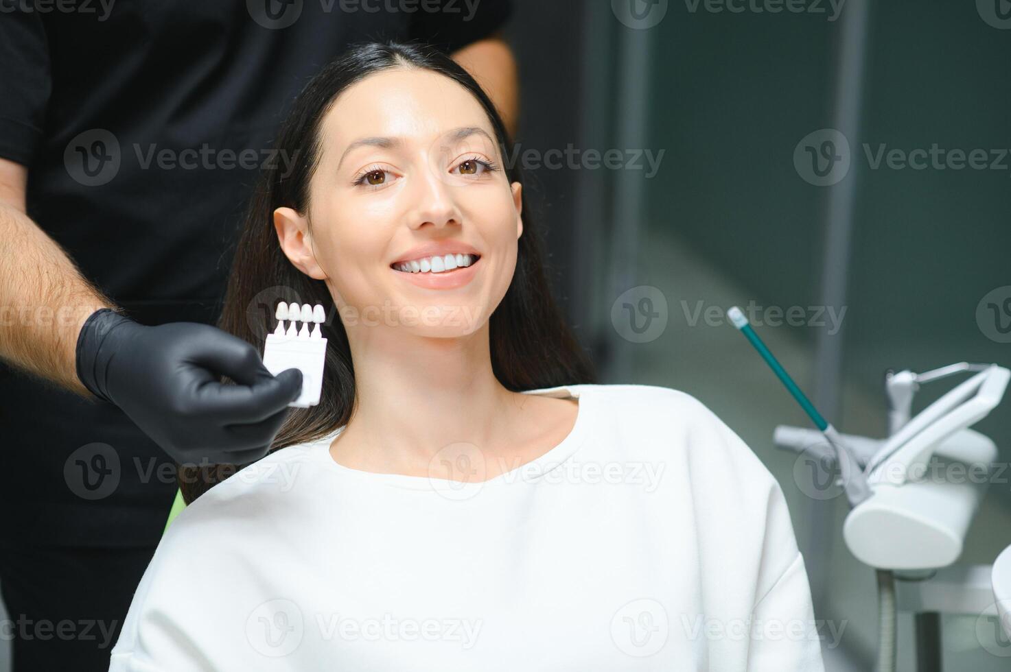 Doctor matching patient's teeth color with palette, closeup. Cosmetic dentistry photo