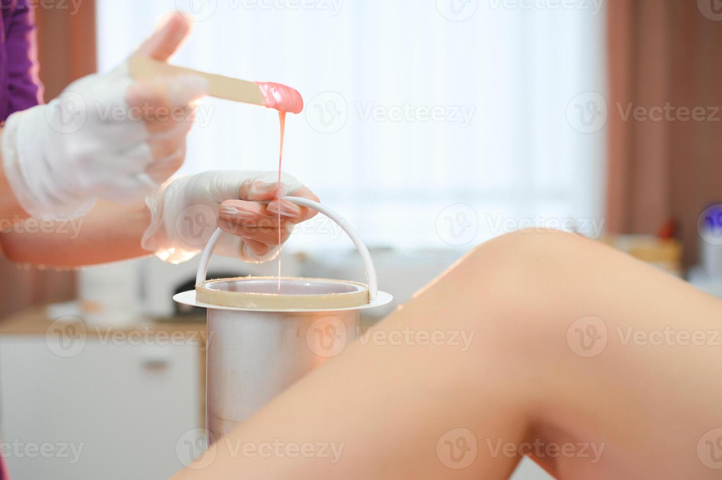 Close up waxing in by a beautician in a spa center photo