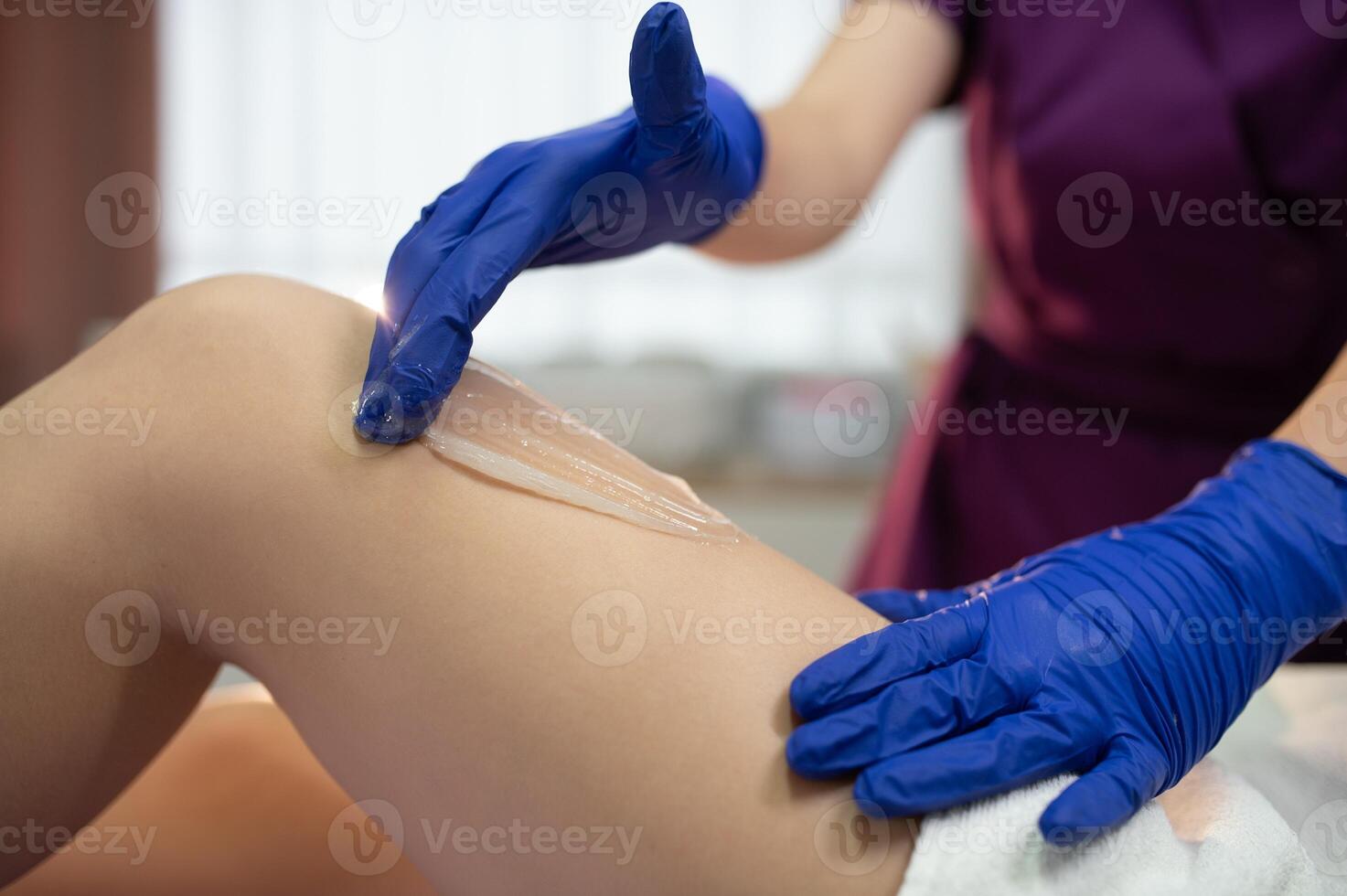 Hair removal at spa luxury studio. Woman legs wax with shugaring. Hot sugar photo