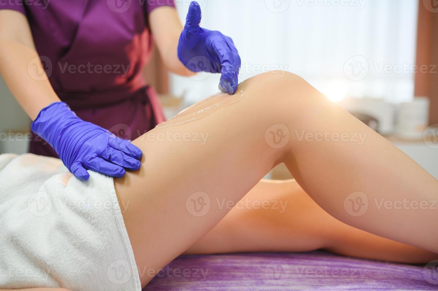 Sugaring epilation with liquate sugar at legs photo