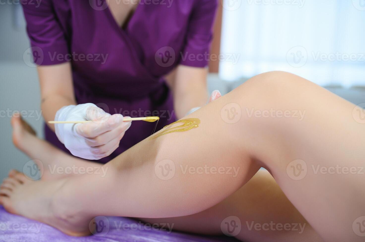 Sugaring epilation with liquate sugar at legs photo