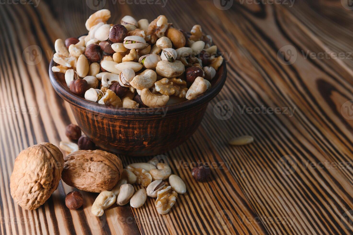 Mixed nuts on wood floor. Organic and fresh nuts. Copy space photo