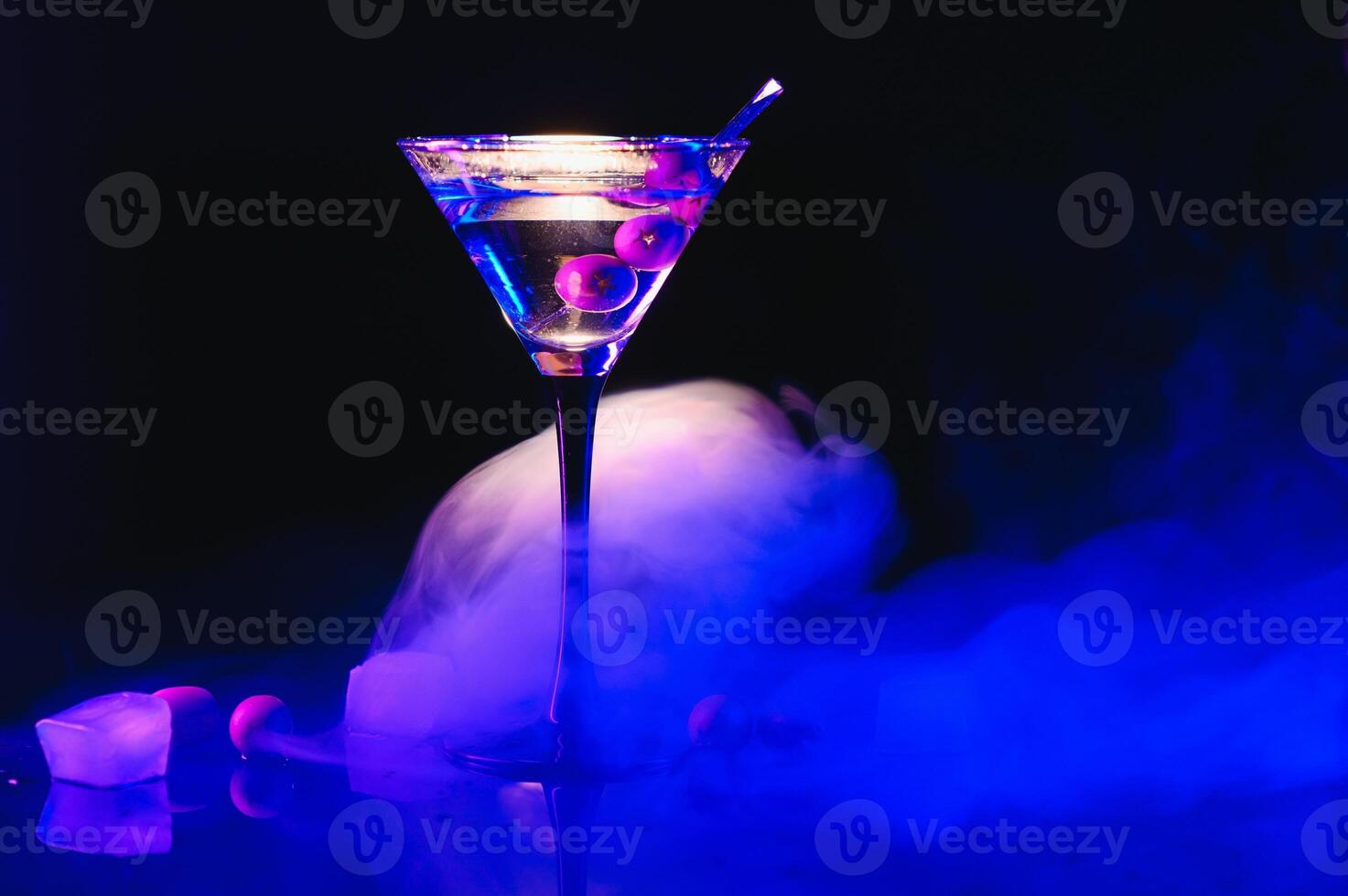 martini cóctel bebida chapoteo con hielo cubitos en neón iridiscente rosado y azul colores. mínimo noche fiesta vida concepto. foto