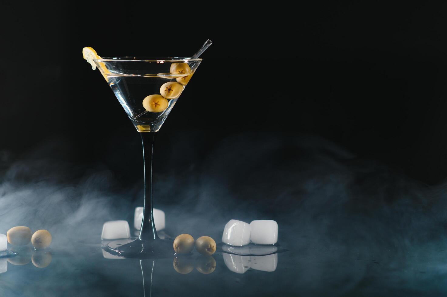 Drink martini. Martini with olives on a black table. Free space for text. photo