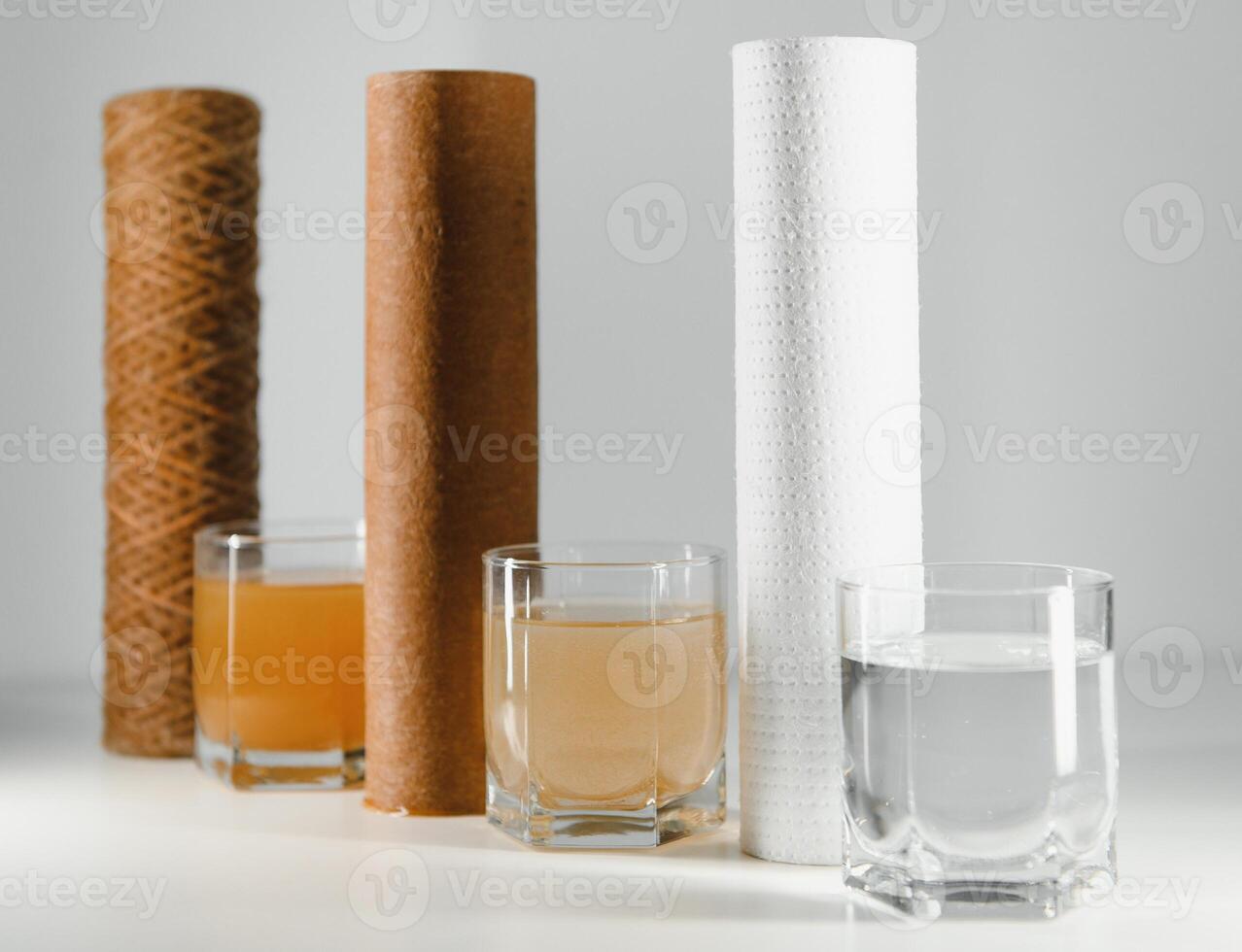 Water filters. Concept of three glasses on a white background. Household filtration system. photo