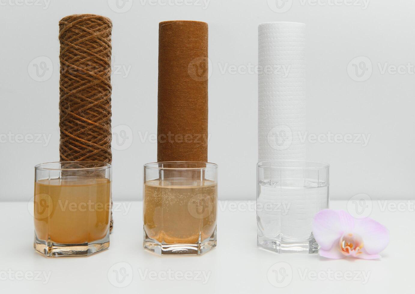 Filter system for water treatment with glasses of clean and dirty water on bright background photo