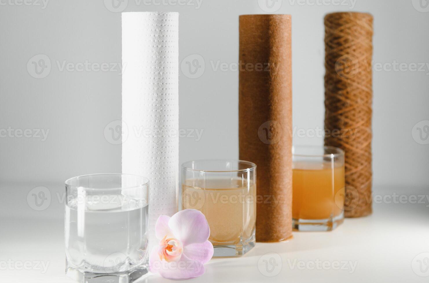 Filter system for water treatment with glasses of clean and dirty water on bright background photo