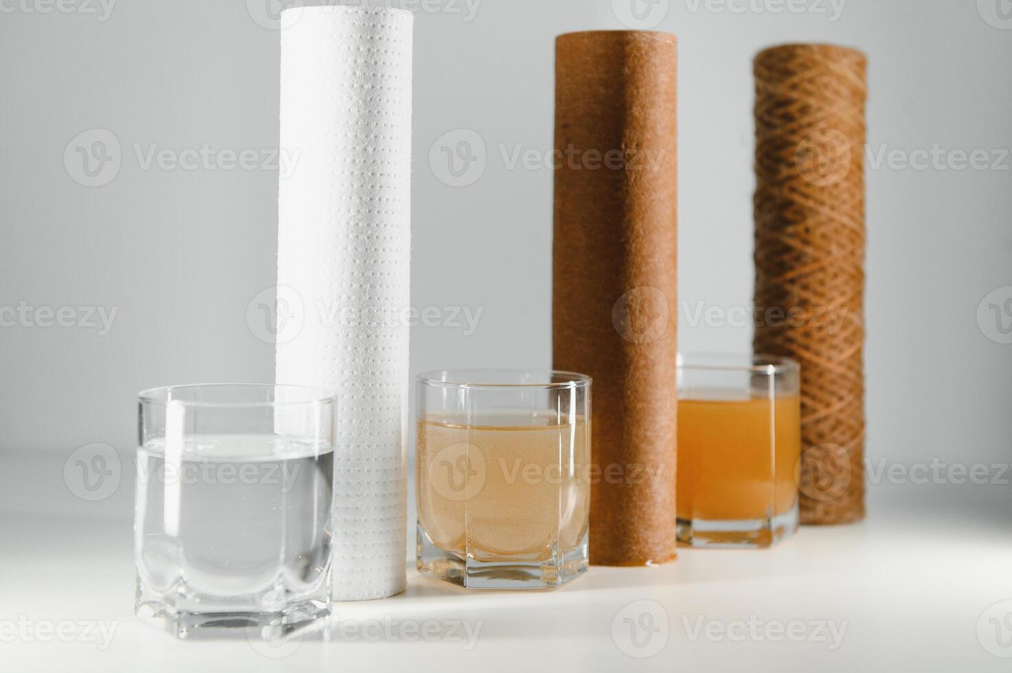 Filter system for water treatment with glasses of clean and dirty water on bright background photo