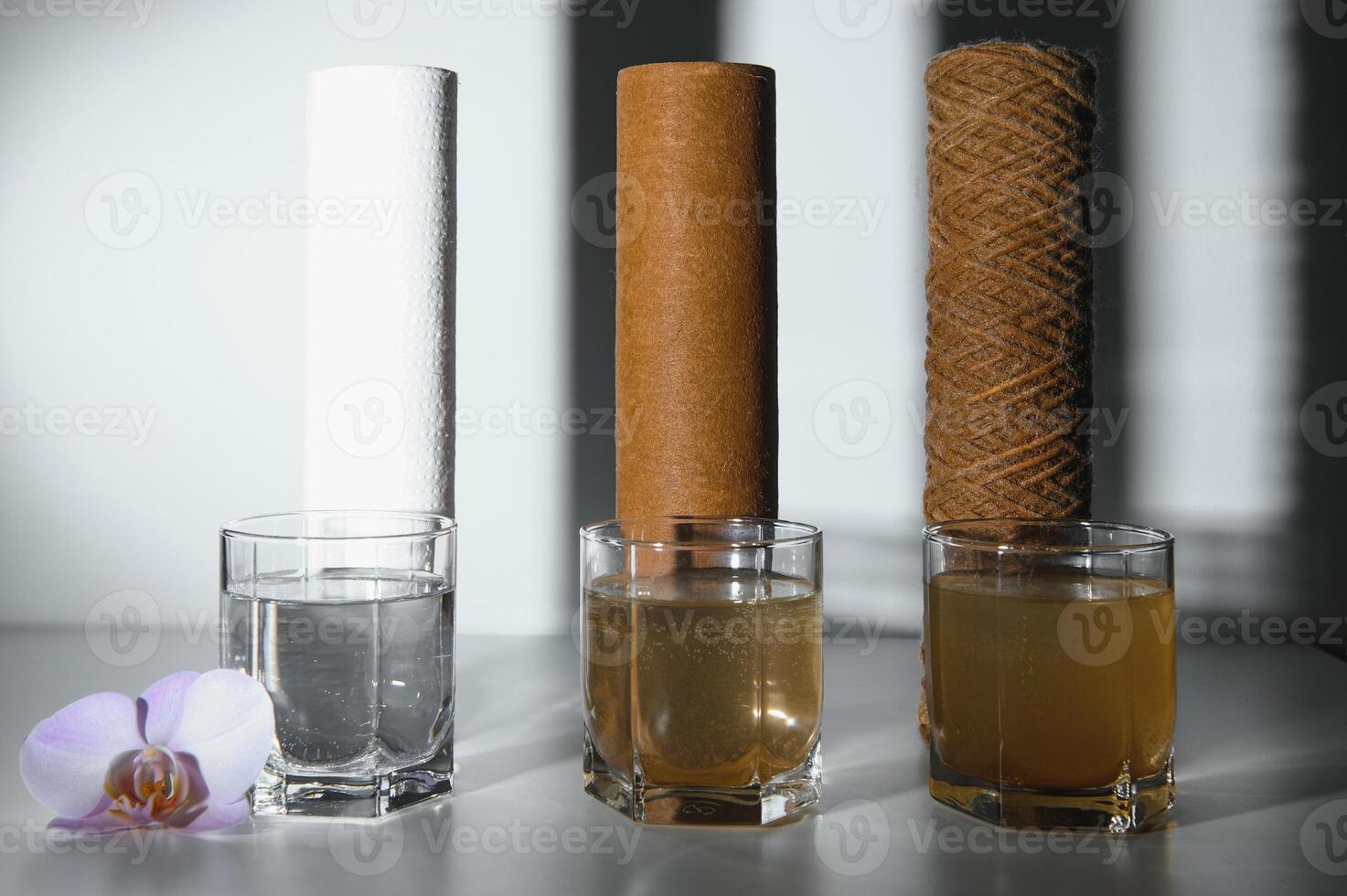 Filter system for water treatment with glasses of clean and dirty water on bright background photo