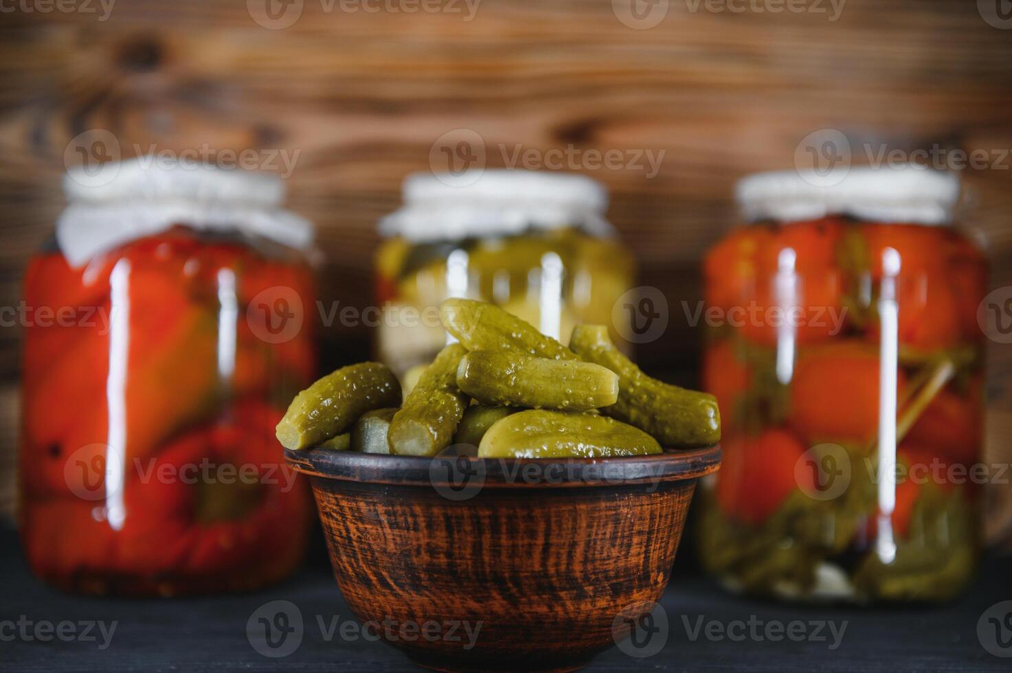 Glass jars with pickled cucumbers pickles, pickled tomatoes and cabbage. Jars of various pickled vegetables. Canned food in a rustic composition. photo