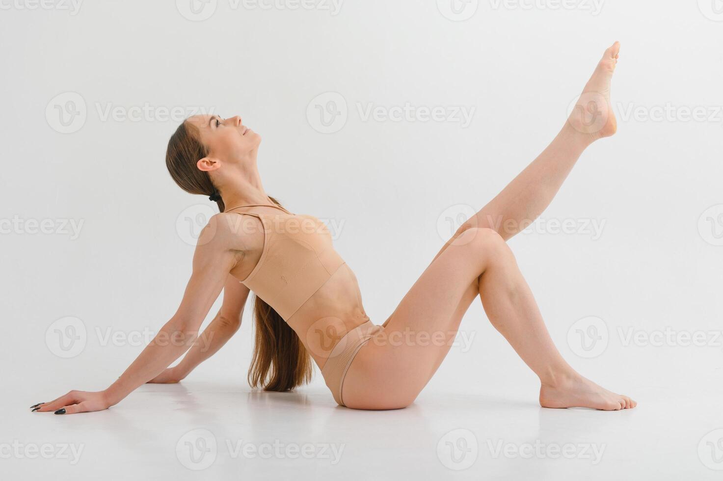 Side view of girl that lying down. Beautiful woman with slim body in underwear is in the studio. photo