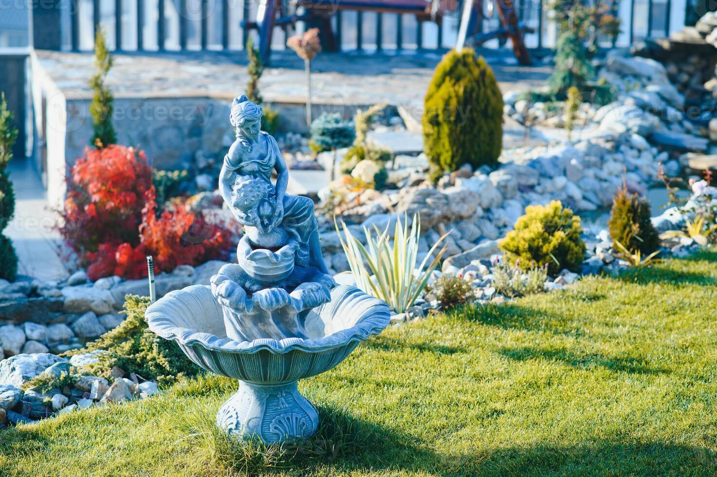 Fountain in the park garden. Water flows from the fountain. photo