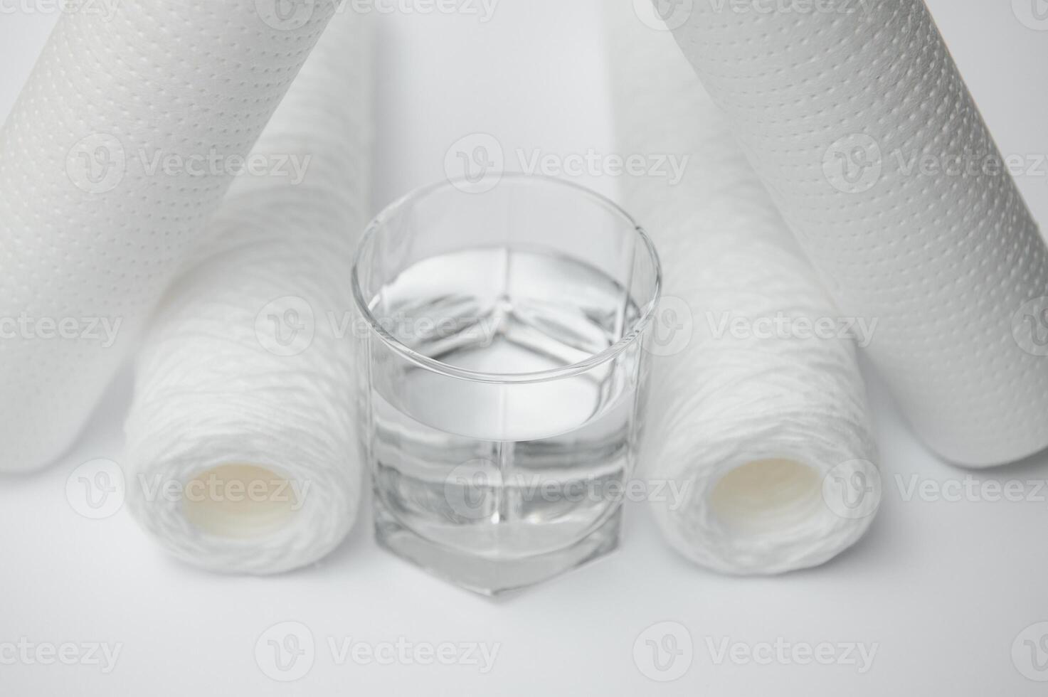 Water filters. Carbon cartridges and a glass on a white background. Household filtration system photo