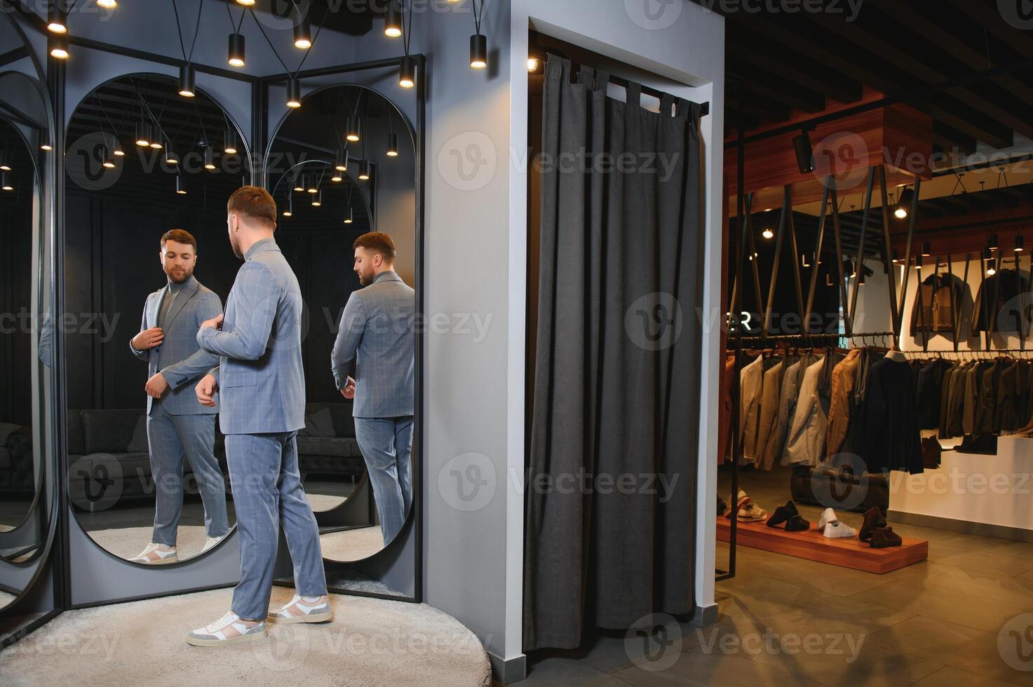 sonriente hombre molesto en traje a espejo en ropa de caballero tienda foto