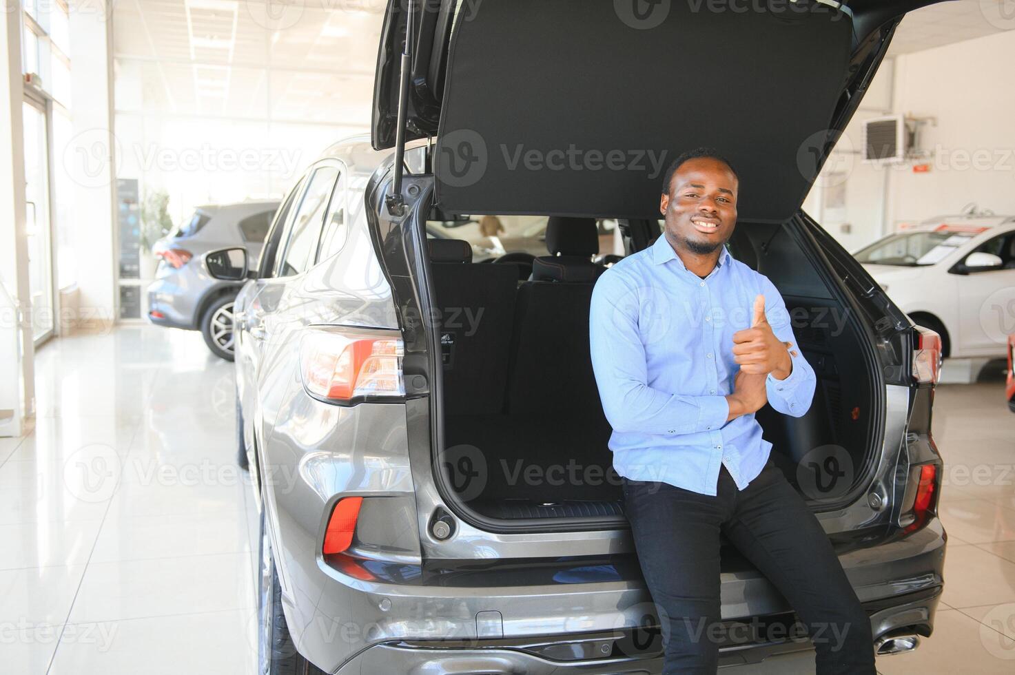 hermoso hombre es en pie cerca su nuevo coche y sonriente foto