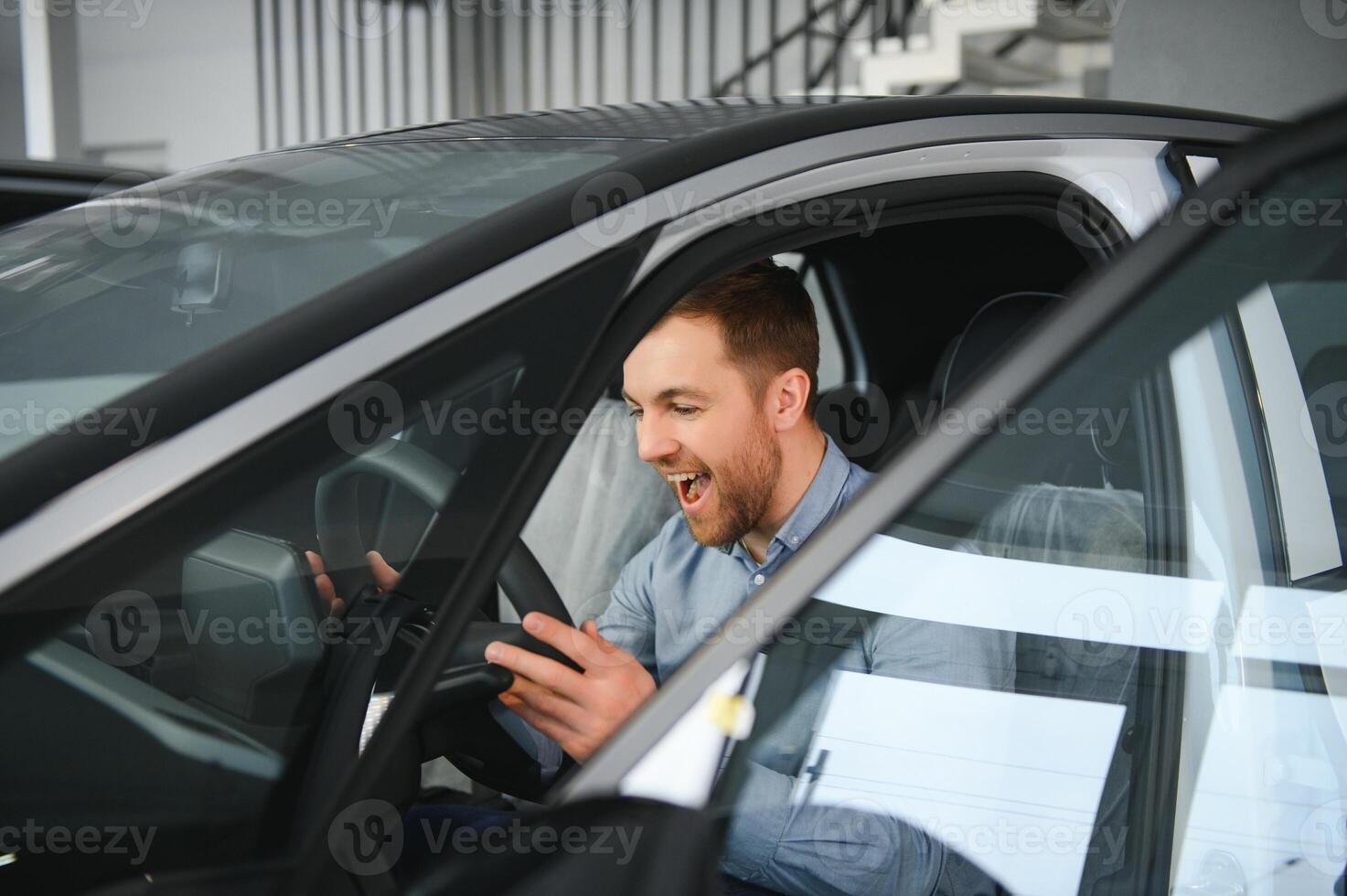 A young man chooses a new car at a car dealership. photo