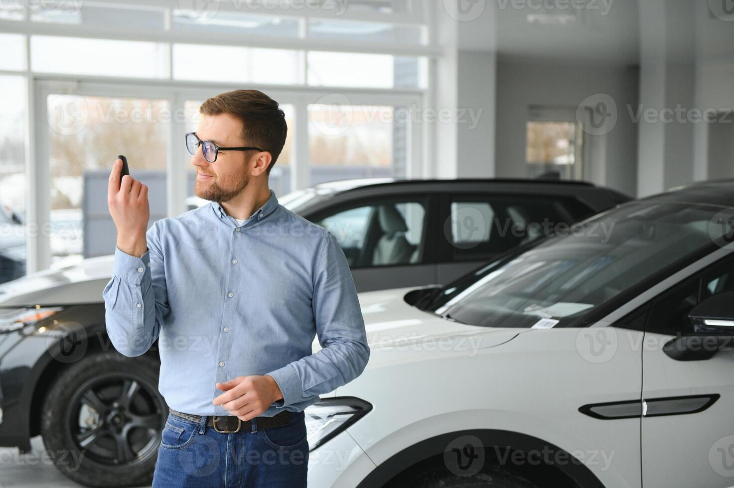 A happy man chooses a new electric car at a car dealership. The concept of buying an ecological car photo