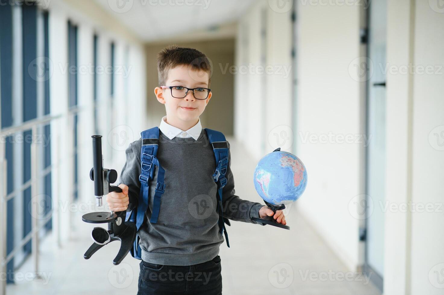 Schoolboy with schoolbag and books in the school. Education concept. Back to school. Schoolkid going to class. Stylish boy with backpack. Boy ready to study. photo