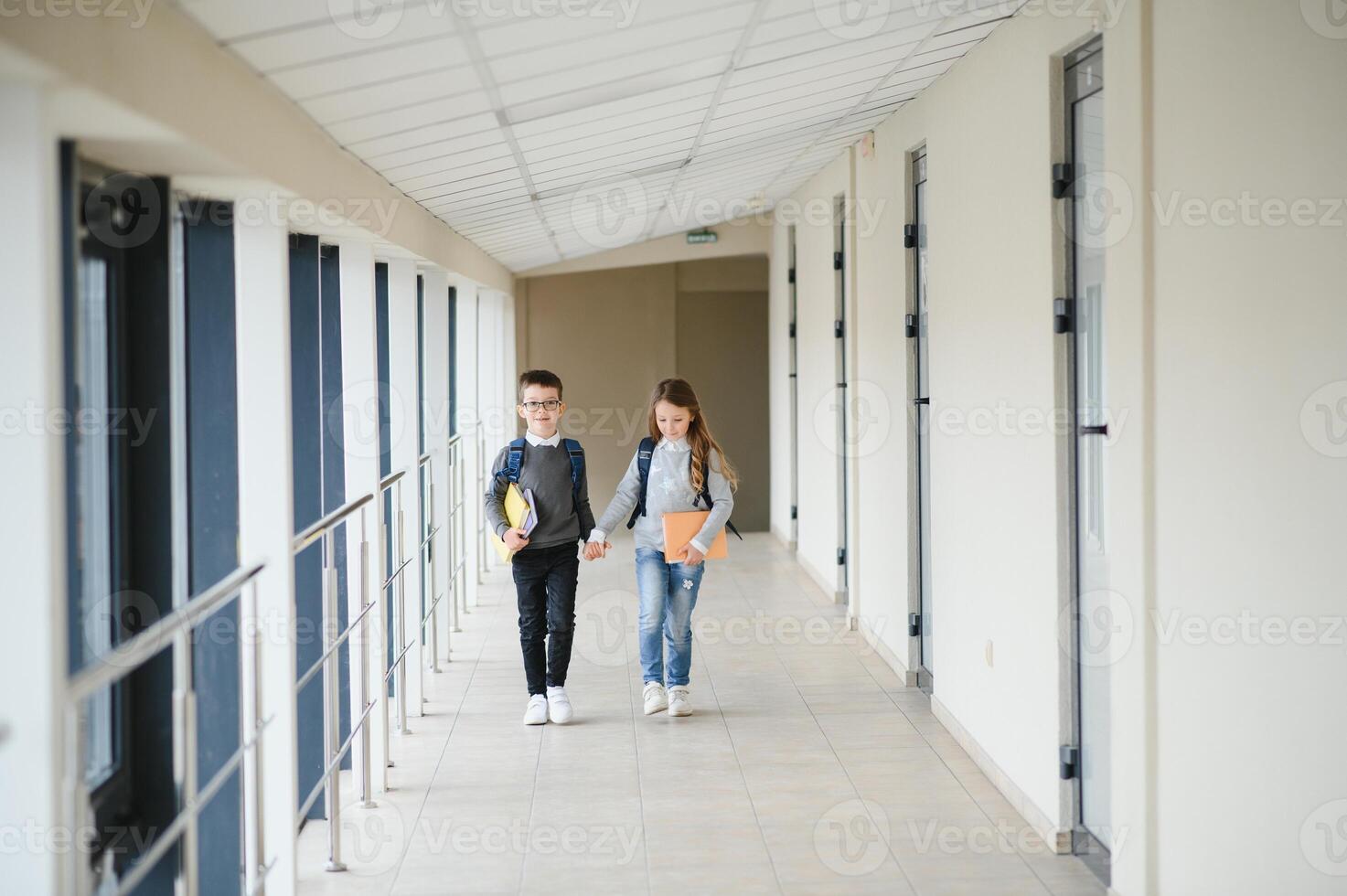 Cute pupils running down the hall at the elementary school photo