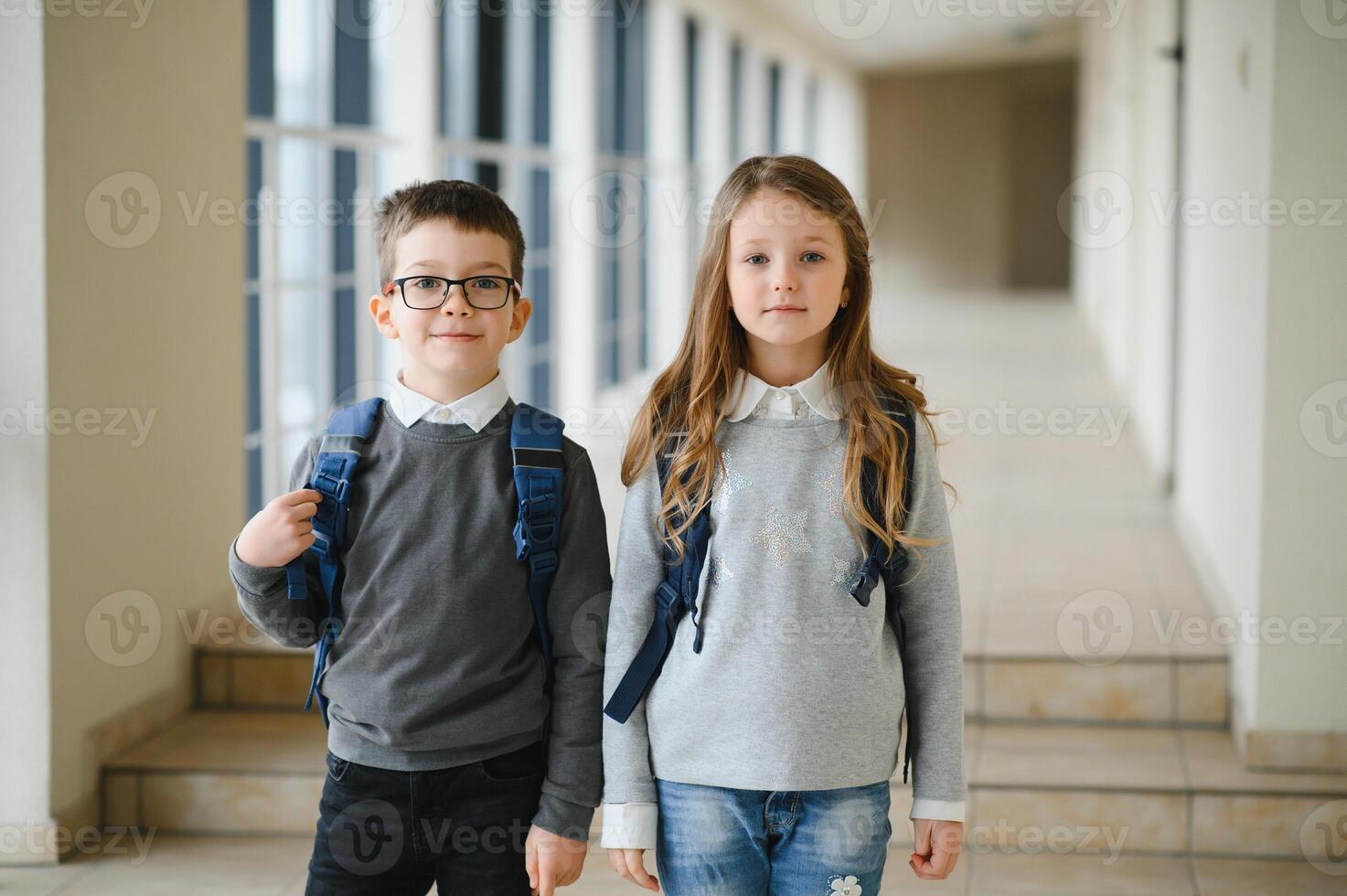 Happy school kids in corridor at school. Learning concept. photo