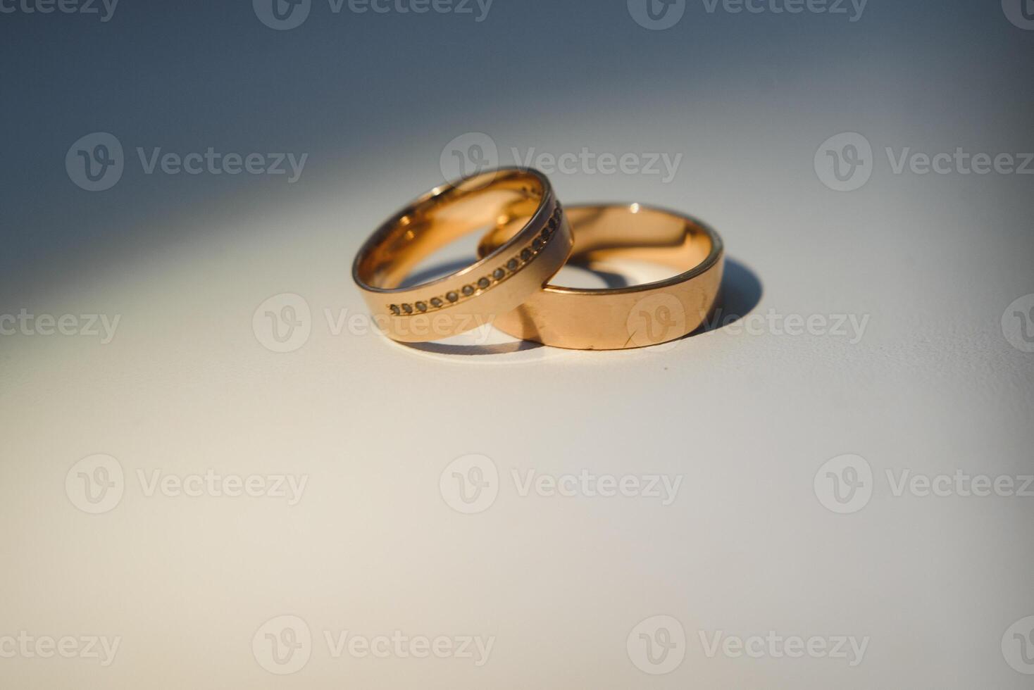 Elegant wedding rings for the bride and groom on a black background with highlights, macro, selective focus. photo