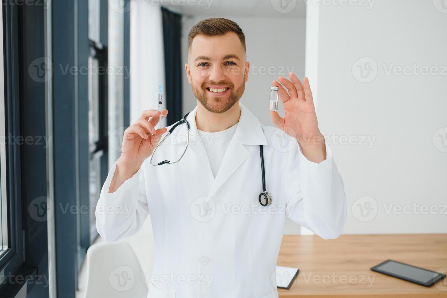 Doctor in PPE holding a vial or bottle vaccine against coronavirus Covid 19 new Omicron variant or strain in his hand, close up. Concept of vaccination, trial and treatment due to SARS-CoV-2 pandemic. photo