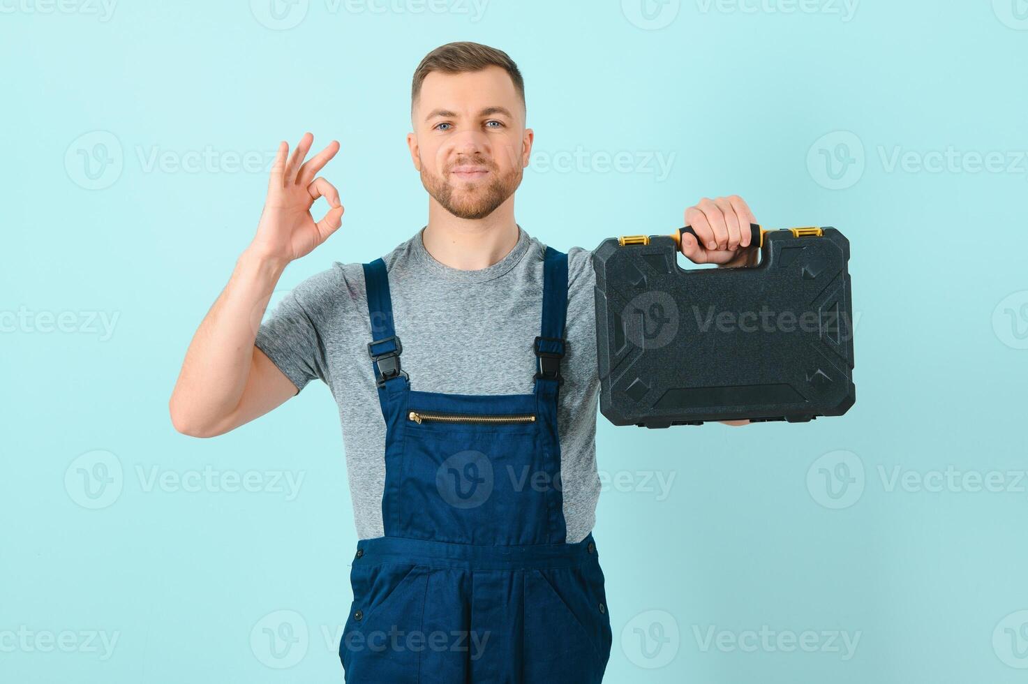 Craftsmen or electrician man over isolated blue background showing an ok sign with fingers photo
