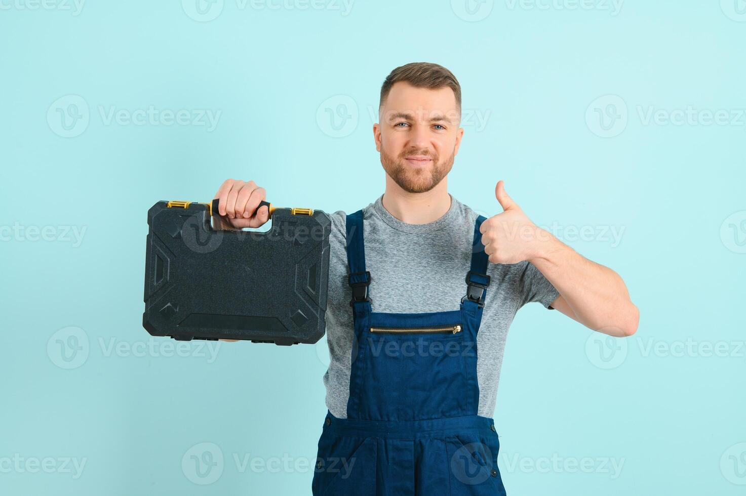 Craftsmen or electrician man over isolated blue background giving a thumbs up gesture photo