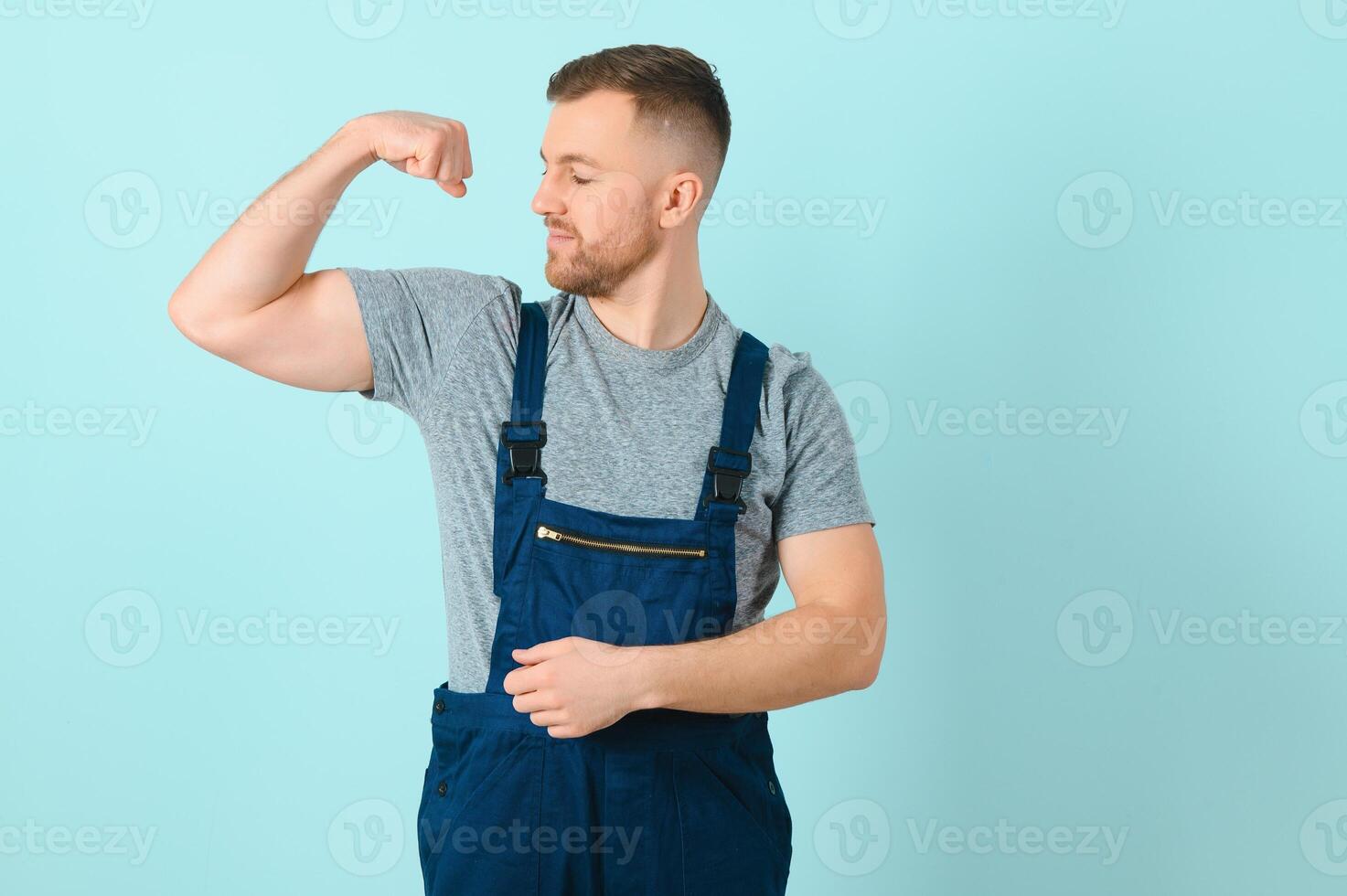 Portrait of smiling worker in uniform isolated on blue background photo
