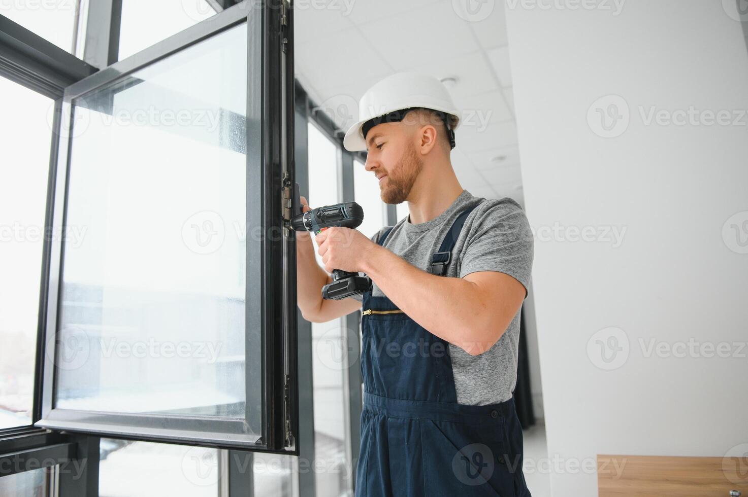 handsome young man installing bay window in new house construction site photo